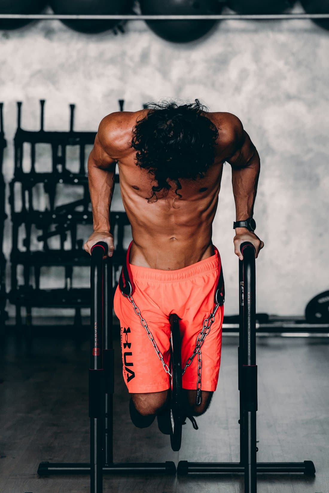 Athlete doing a weighted dip on parallel bars