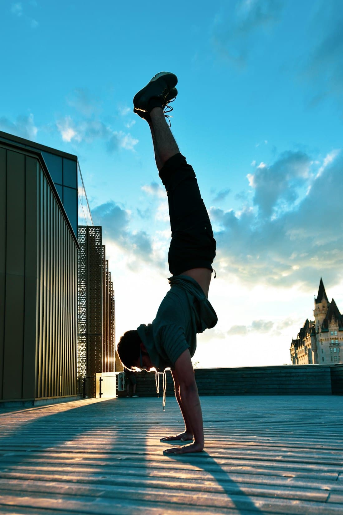Athlete in a handstand on a rooftop at sunset
